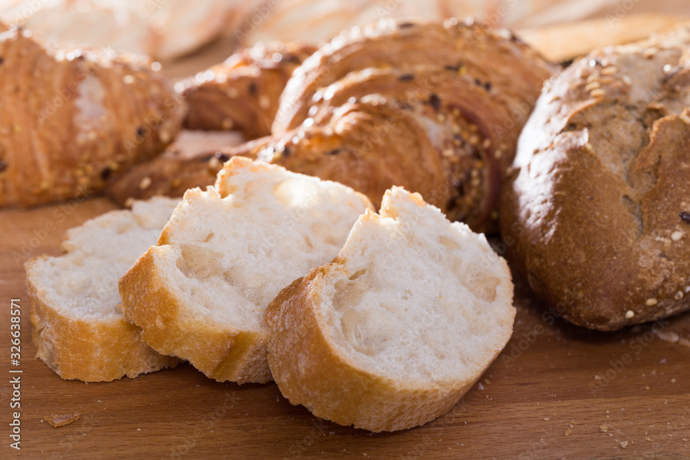 slices of wheaten bread on wooden surface slices of wheaten bread on wooden surface