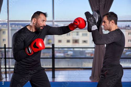 Kickboxer hitting mitts with coach