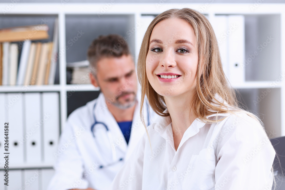 Satisfied happy beautiful smiling female with doctor at his office. High level and quality medical service, therapeutist consultation appointment, work and career, physical, healthy lifestyle concept Satisfied happy beautiful smiling female with doctor at his office. High level and quality medical service, therapeutist consultation appointment, work and career, physical, healthy lifestyle concept