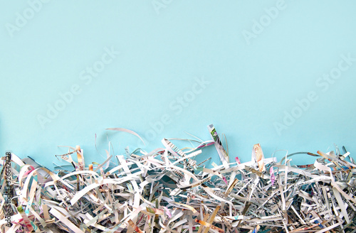 Shredded paper on light blue background. Selective focus image. photo