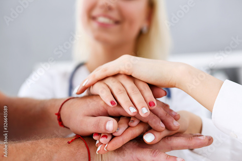 Group of doctor crossed arms in pile for win closeup. High five  cooperation initiative achievement  heap  stack  people cure strategy  colleague competition  heal alliance  hospital visit concept