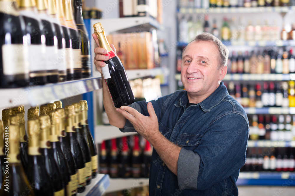 Portrait of an elderly man buying a wine