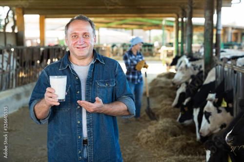 Man is standing with glass of milk