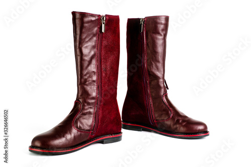 Women's leather boots in burgundy, fastened with a zipper. Background for women's shoes.