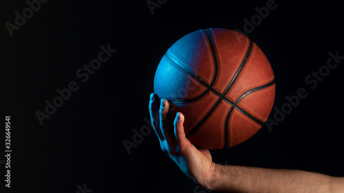 Front view of basketball held by male hand © FreepikCompany