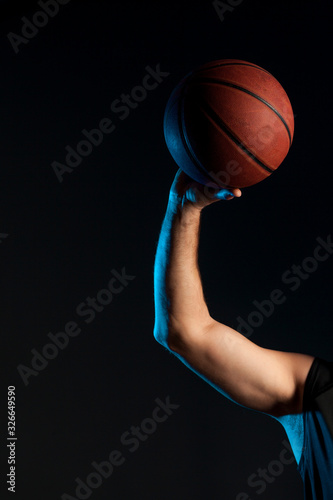 Front view of basketball player arm holding up ball © FreepikCompany