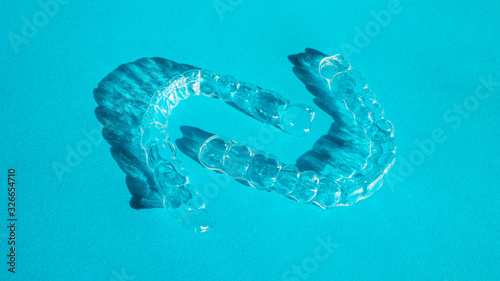Invisible aligners teeth brackets on blue background