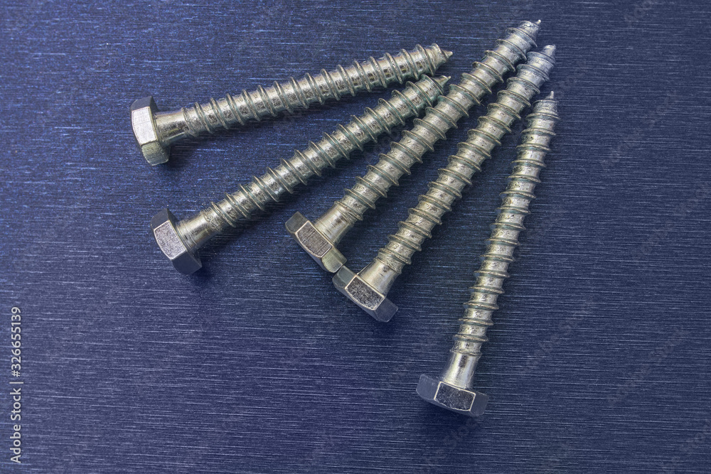 Galvanized screws on a blue background. Wood screws. Galvanized screws on a blue background. Wood screws.