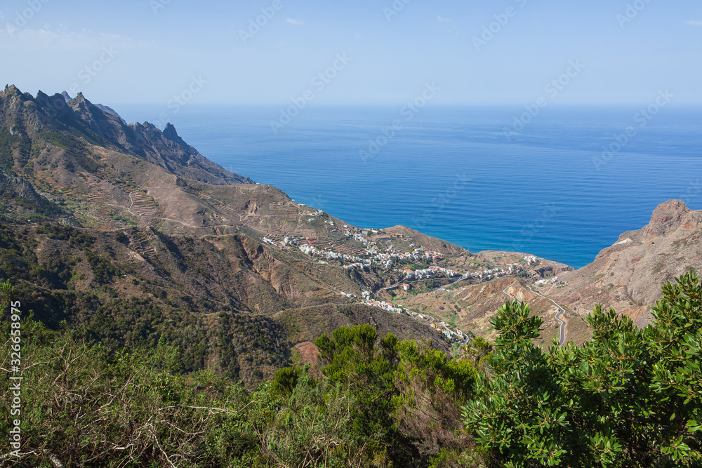 Aerial view of the small village surrounded with Anaga mountains on the Atlantic ocean background, Tenerife, Canary Islands, Spain.