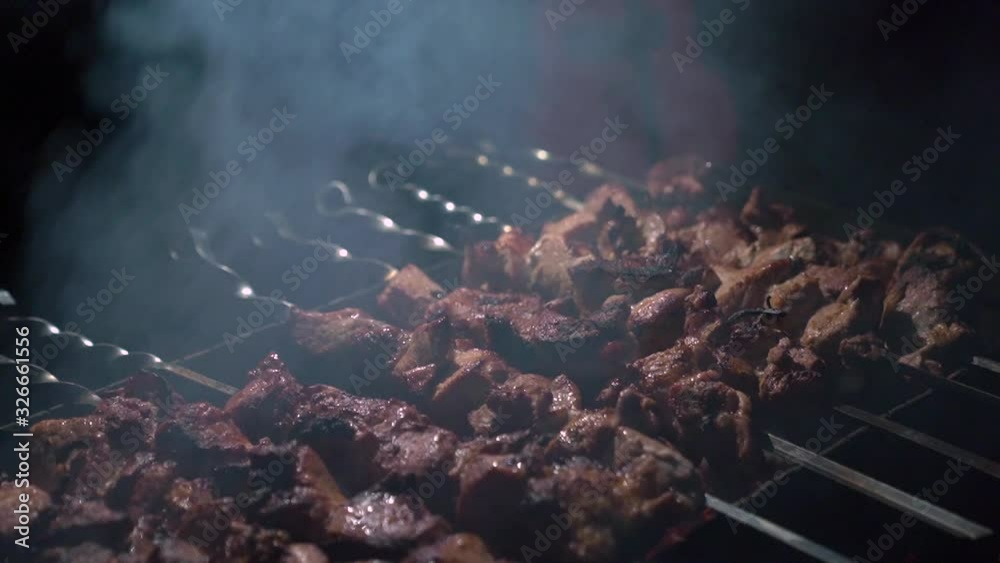 Barbecue on grill at night man hands grills pork meat closeup camera movement slow motion Barbecue on grill at night man hands grills pork meat closeup camera movement slow motion