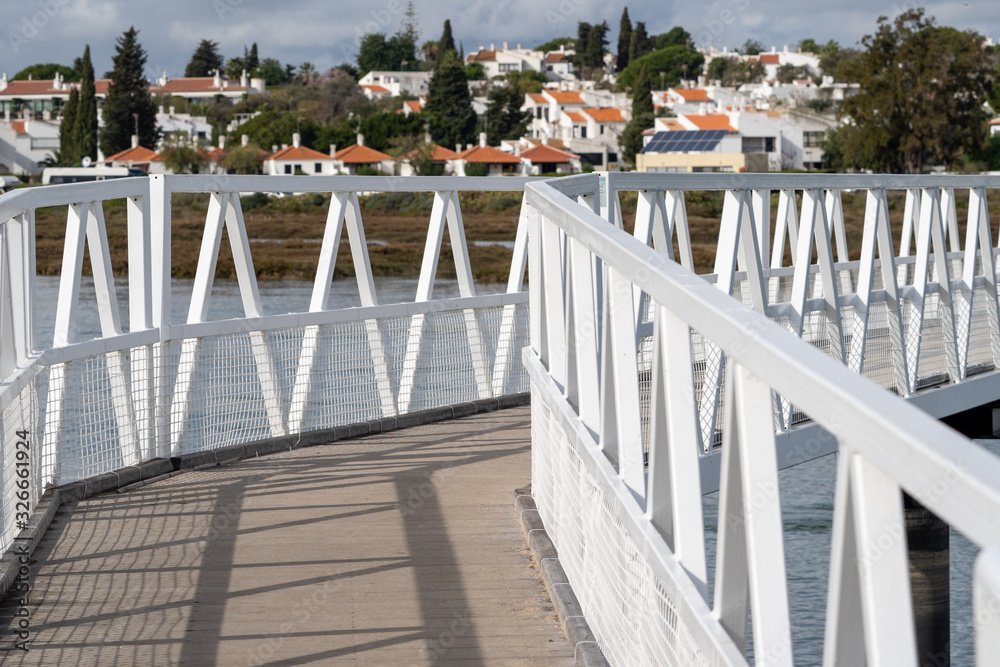 White pedestrian bridge connecting Barril Beach to Tavira Portugal, going over the wetlands and marsh