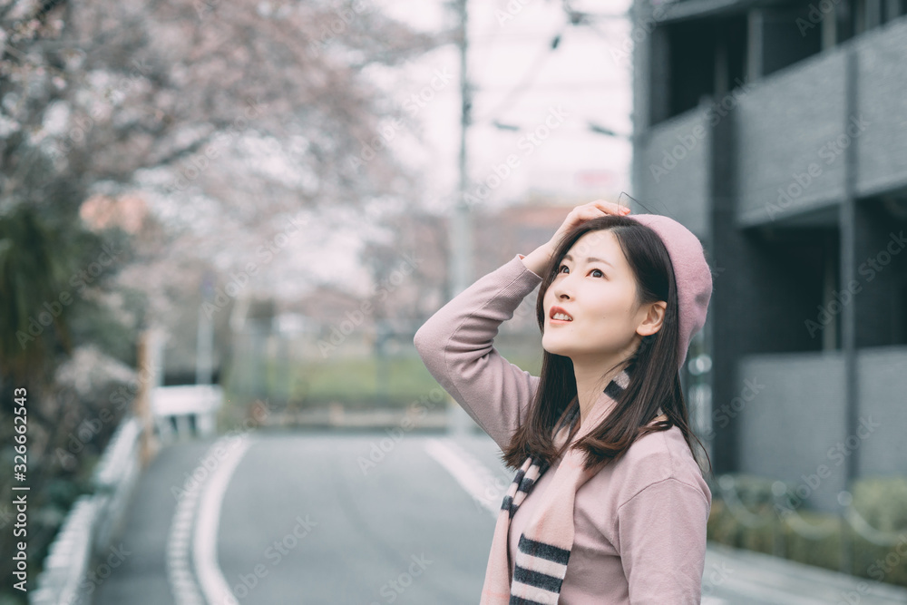 Obraz premium Under the cherry tree, the girl smiles gently