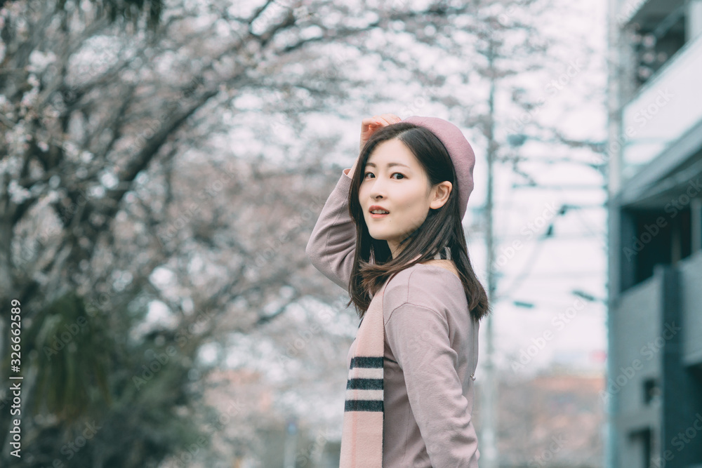 Under the cherry tree, the girl smiles gently Under the cherry tree, the girl smiles gently