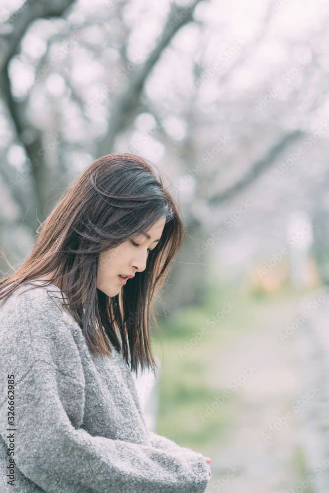 Under the cherry tree, the girl smiles gently Under the cherry tree, the girl smiles gently