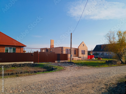 new house with an orange roof and a brown fence.