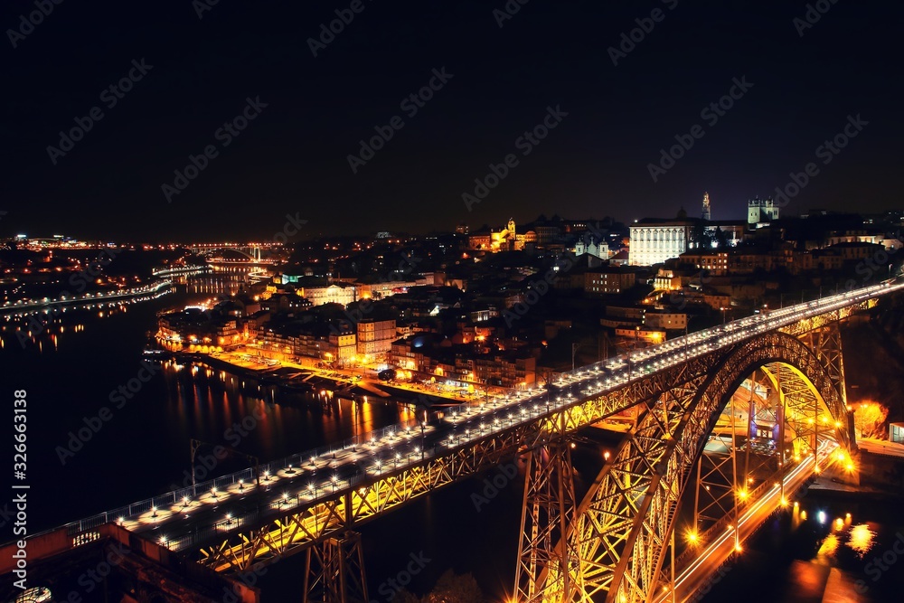 Obraz premium Vista nocturna de la desembocadura del río Douro a su paso por las ciudades de Oporto y Vila Nova de Gaia en Portugal y del famoso puente Don Luis I que las comunica.
