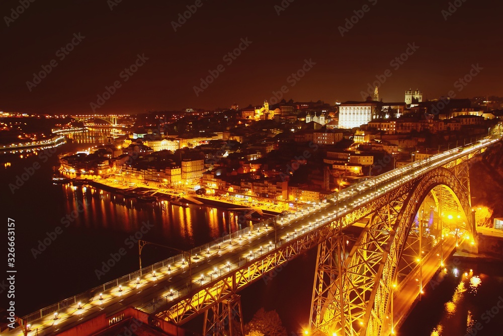 Vista nocturna de la desembocadura del río Douro a su paso por las ciudades de Oporto y Vila Nova de Gaia en Portugal y del famoso puente Don Luis I que las comunica.