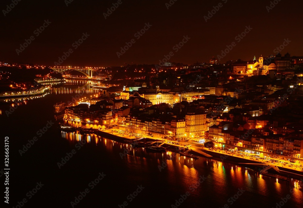 Vista nocturna de la desembocadura del río Douro a su paso por las ciudades de Oporto y Vila Nova de Gaia en Portugal.