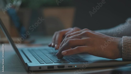 Woman sitting at desk and typing with her laptop