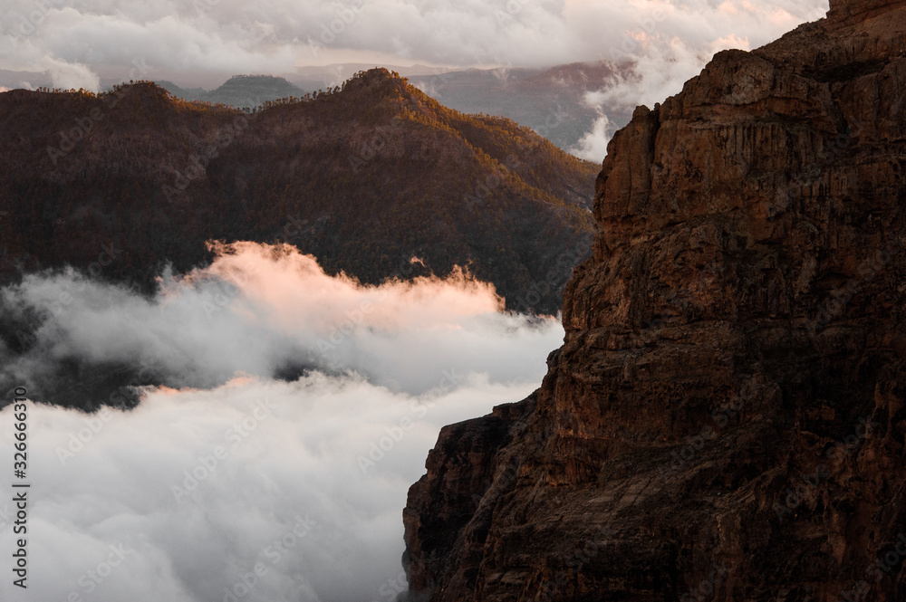 Landscape of mountain tops peeking out of clouds