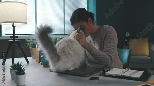 Woman cuddling her beautiful cat on the desk
