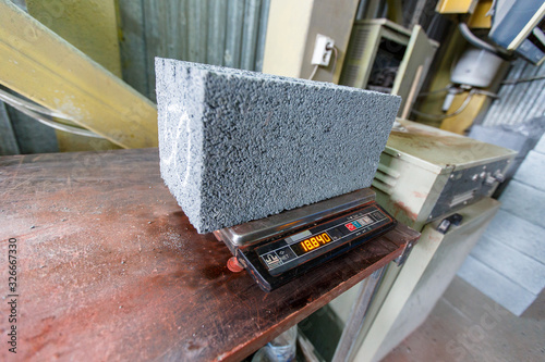 Terekhovka, Russia - New cinder block brick lies on an industrial scale in a laboratory