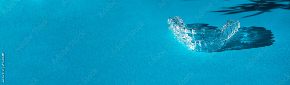 Invisible aligners teeth brackets on blue background