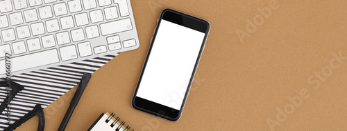 Foto Mobile screen isolated on office desk. Mock up.