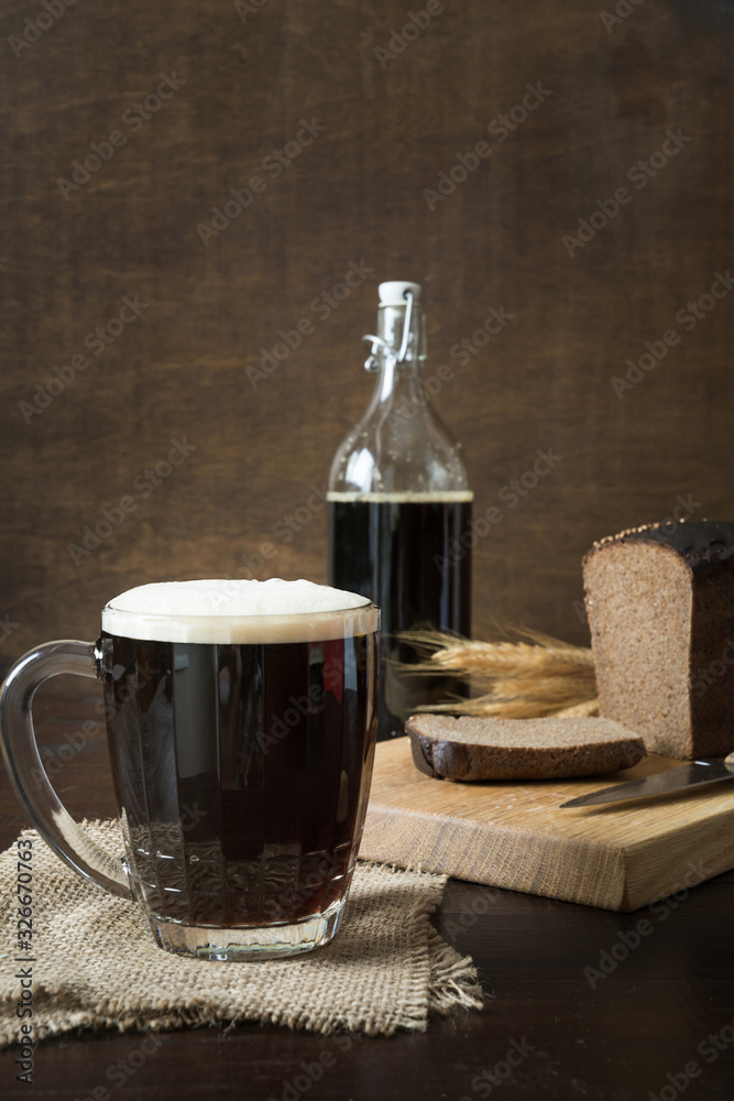 Russian traditional drink fermented kvass from rye bread in special half-liter mug on dark background. Vertical format. Russian traditional drink fermented kvass from rye bread in special half-liter mug on dark background. Vertical format.
