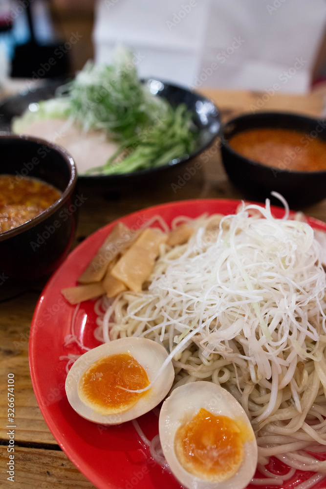 Japanese ramen with bean sprout and soft boiled egg on a red bowl.
