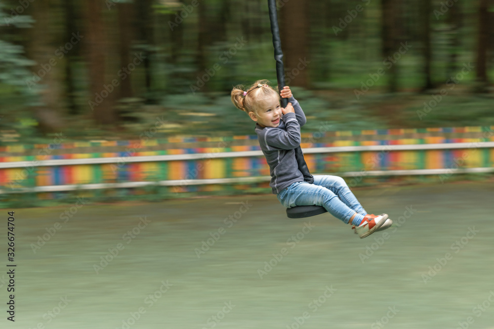 a little girl 3-4 years old flies on a bungee with a high speed. wiring