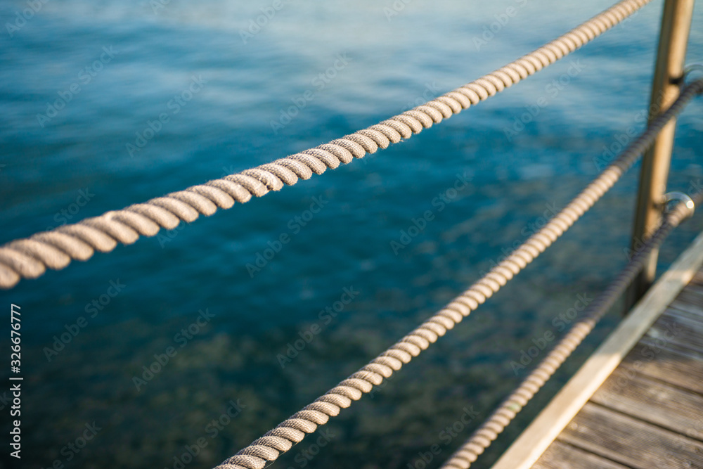 Obraz premium Close up of rope fence on wooden pier