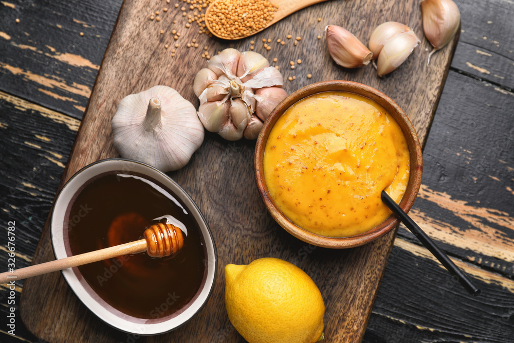 Φωτογραφία Bowl of tasty honey mustard sauce with ingredients on dark wooden background