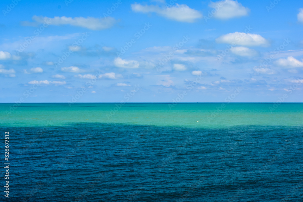 Obraz premium the sea surface is light turquoise and blue against a cloudy sky