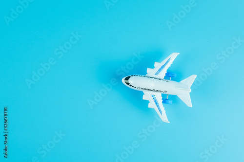 Fototapeta Naklejka Na Ścianę i Meble -  Top view airplane model on blue background with copy space for text