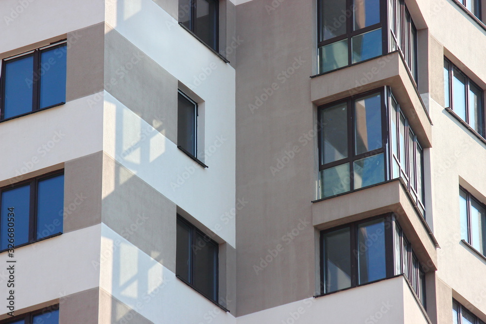 Parts of the modern facade of apartment buildings made of glass and concrete with highlights on the windows in beige colors. Trends in buildings Parts of the modern facade of apartment buildings made of glass and concrete with highlights on the windows in beige colors. Trends in buildings