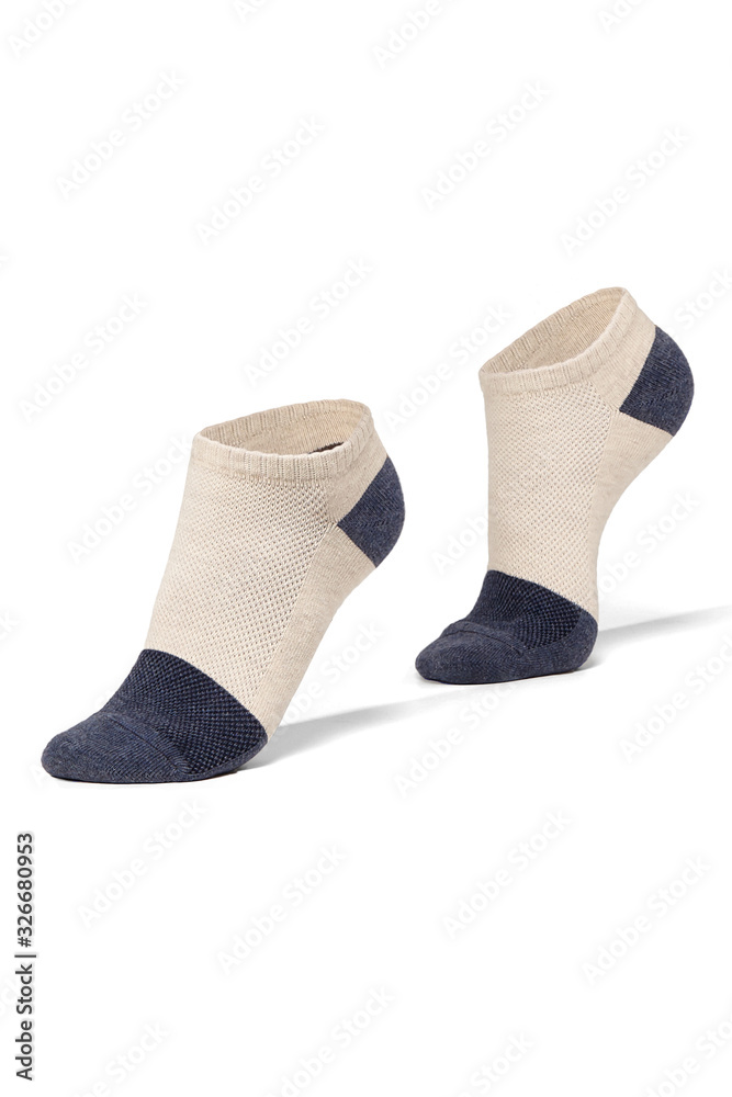 Subject shot of feet on tiptoe in white cotton socks with navy blue toes and heels. The photo is made on the white background. Subject shot of feet on tiptoe in white cotton socks with navy blue toes and heels. The photo is made on the white background.