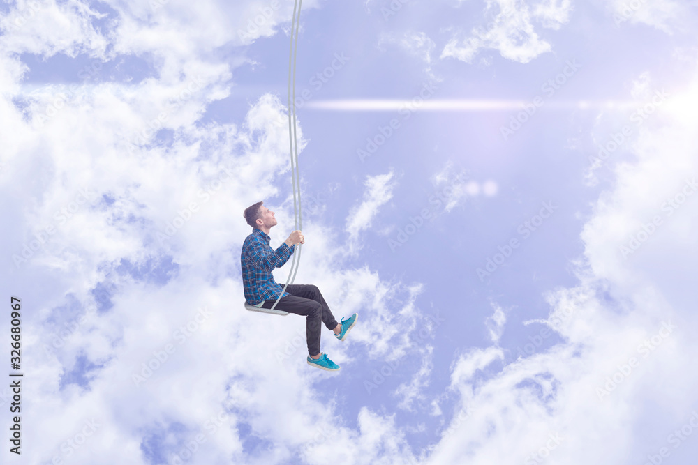 flying high in the sky with clouds, man on a swing, relax and dream in mind concept flying high in the sky with clouds, man on a swing, relax and dream in mind concept