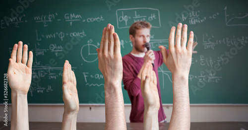 many puppil or students hands raised with a solution on a lesson or lecture with a teacher speaking photo