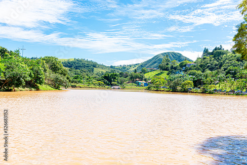 lago com água barrenta e montanhas ao fundo em uma cidade no interior de São Paulo, Brasil