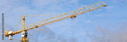 Big hoisting crane standing at blue sky