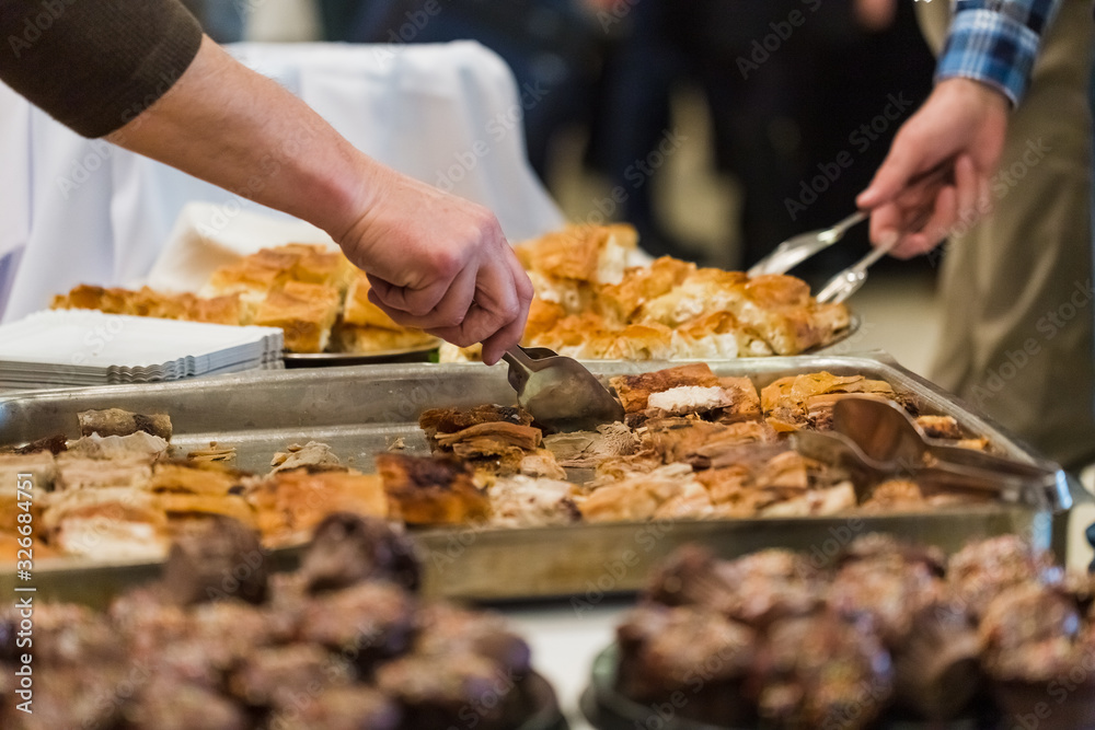 People serving themselves with food at restaurant event or business conference. People serving themselves with food at restaurant event or business conference.
