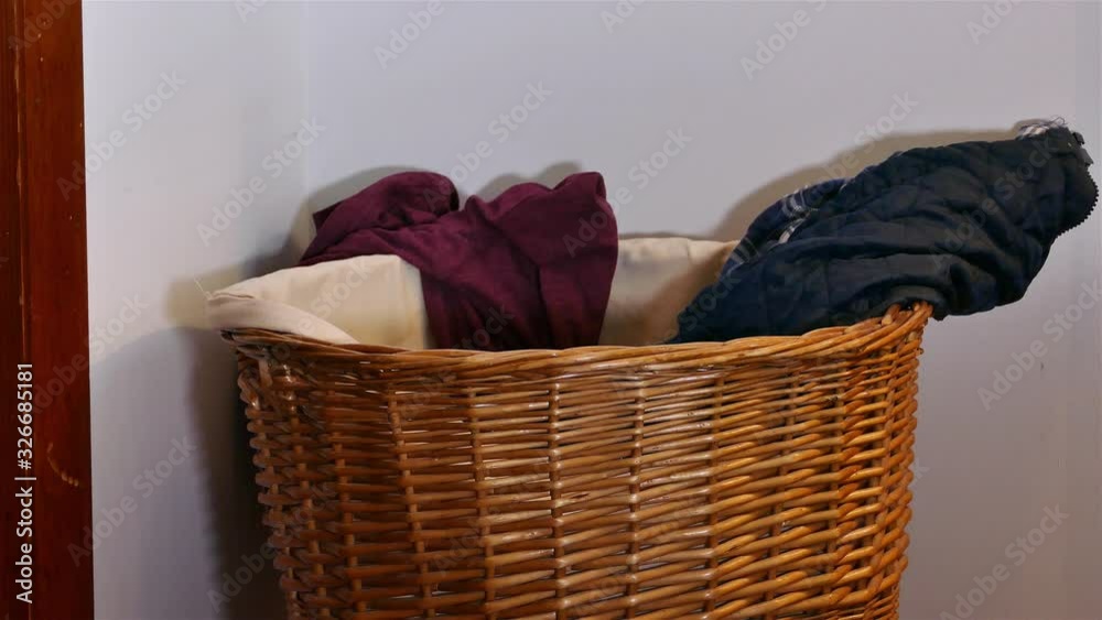 Throwing dirty laundry inside laundry basket