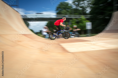  Bmx rider jumping over on a U ramp in a skatepark (motion blurred image) photo