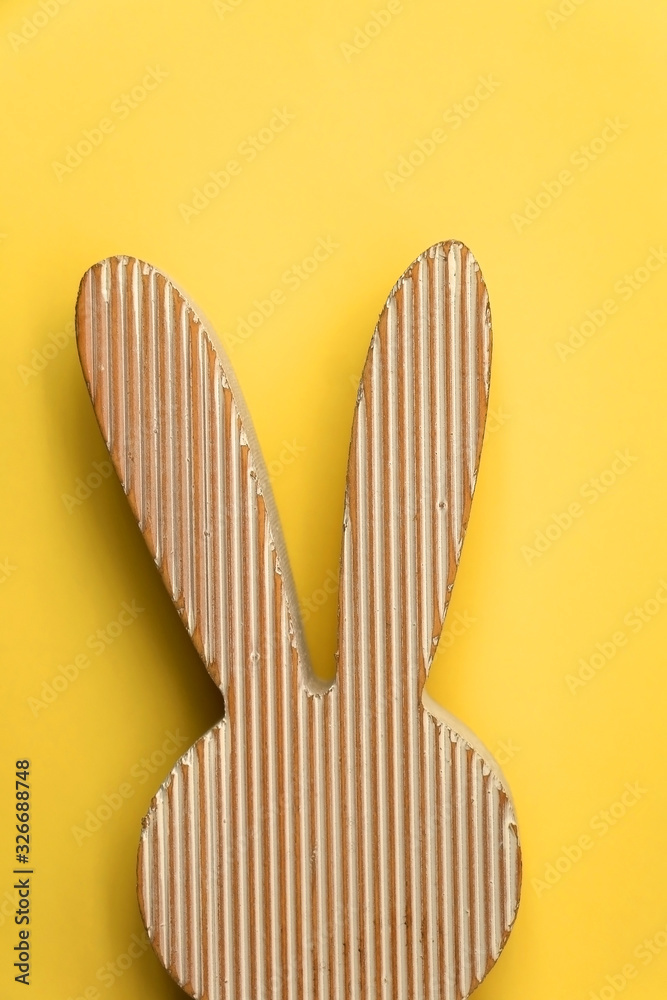 Wooden Easter bunny decoration in front of bright yellow background. Wooden Easter bunny decoration in front of bright yellow background.