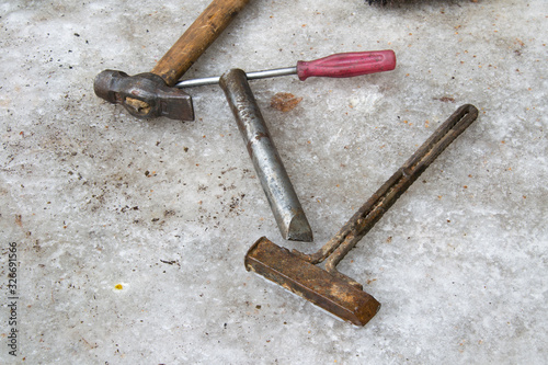 Old dirty tool: hammer, screwdriver, chisel, homemade rusty hammer wallow on ice in winter. A very scary repairman tool in Russia.