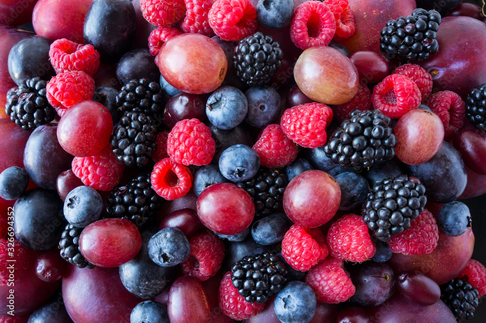 Background of fresh vegetables and fruits. Ripe blackberries, blueberries, plums, pink grapes, raspberries. Mix berries and fruits. Top view. Background berries and fruits. Black-blue and red food. Background of fresh vegetables and fruits. Ripe blackberries, blueberries, plums, pink grapes, raspberries. Mix berries and fruits. Top view. Background berries and fruits. Black-blue and red food.