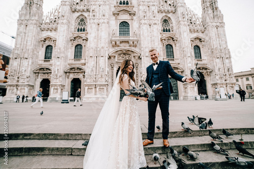 groom and bride posing in front of the church