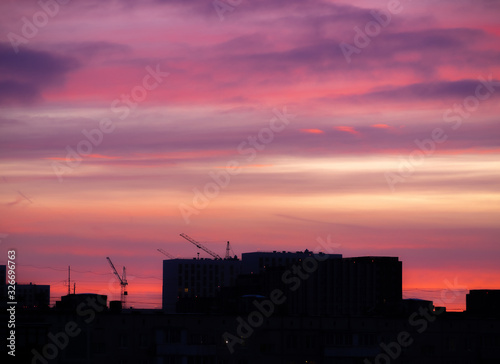 Colorful cloudy epic sky on sunrise, over the panoramic silhouette of the buildings. Moscow city skyline, morning urban landscape.