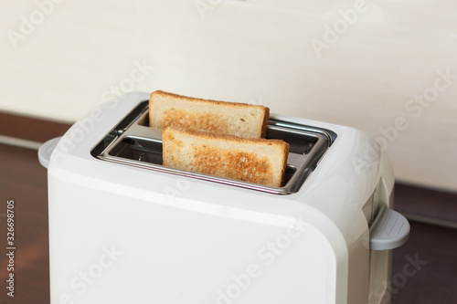 Slices of toasted bread in a white toaster.